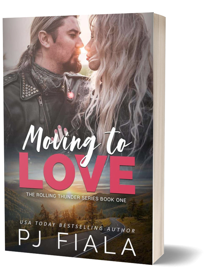 3D paperback edition of Moving to Love by USA Today bestselling author PJ Fiala. The cover features a rugged biker hero and a blonde heroine standing close beneath a glowing sunset, with a scenic country road and forest in the background.